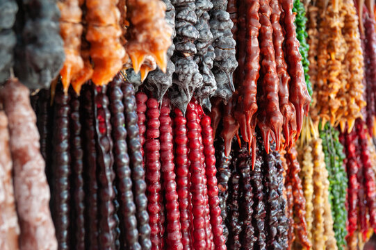 Traditional Georgian churchkhela candy hanging display. Homemade sweet nut dessert texture