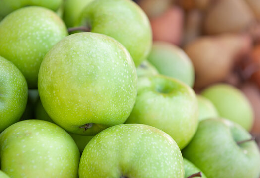 Fresh green apple harvest background. Organic crisp fruit market pile