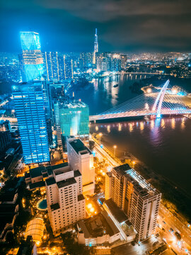 Aerial night view of Ho Chi Minh City skyline with glowing skyscrapers and neon lights, Drone panorama of Saigon downtown, illuminated towers and busy streets of vibrant city