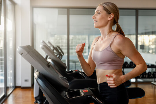 Determined woman running on a treadmill at the gym