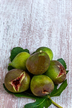 Several Figs Are Arranged on a Green Fig Leaf