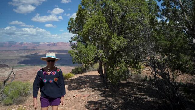 A senior woman hikes gracefully on Gander Trail at Gooseberry Mesa, surrounded by the breathtaking landscapes of Zion National Park.