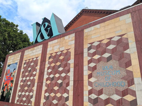 Geometric stone facade and large teal logo of the Young VandA Museum of Childhood in London