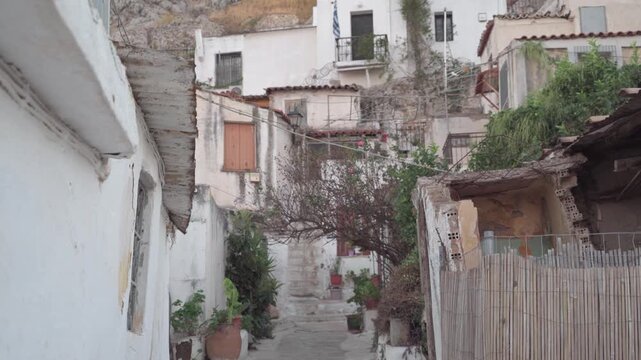 Tightly packed whitewashed houses with steps, balconies and plants climbing the slope in Anafiotika, the island-style quarter of Plaka in Athens, Greece.