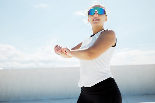 Bright sunny day finds a woman stretching outdoors, showcasing her athleticism and determination