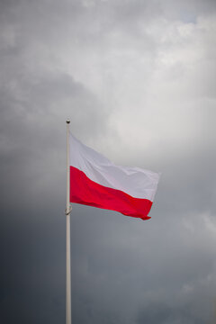 Die polnische Nationalflagge vor einem dramatischen bew&ouml;lkten Himmel