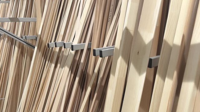 Brightly lit hardware store showcases rows of wooden boards in various sizes and textures. Shoppers browse, inspecting the materials for their next project.