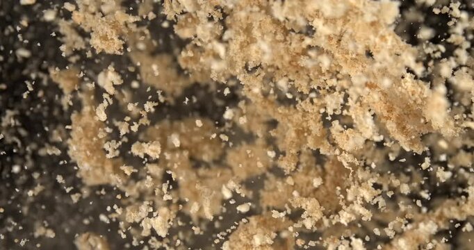Bread crumbs falling in slow motion 1000 fps on black background