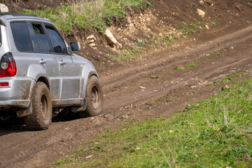 The car drives on a muddy, bad off-road road. © Daniel