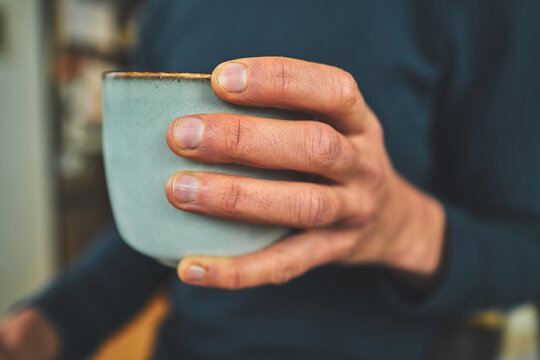 Close-Up of a Hand Holding a Handmade Ceramic Tea Cup