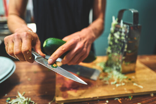 Man Trimming the End of a Zucchini with a Kitchen Knife