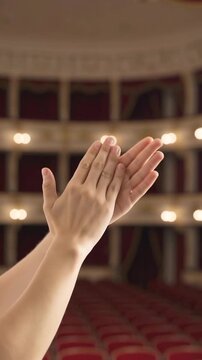 Person clapping hands in theater