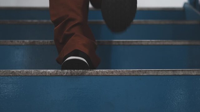 Close-Up of Feet Climbing Blue Stairs, Slow Motion