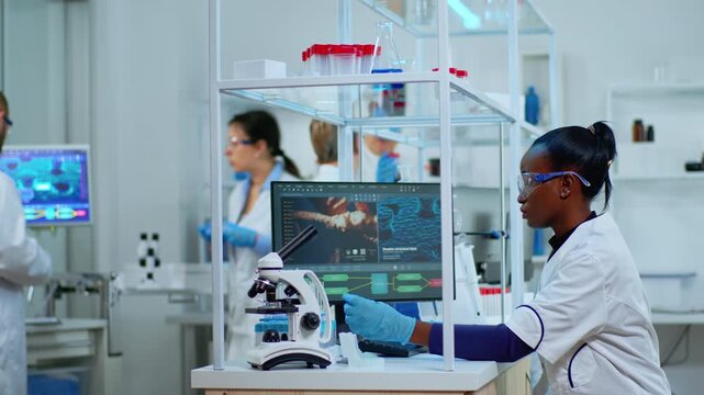 Test tubes, scientist and laboratory research with a woman working at a microscope bench beside molecular images on a monitor, for biomedical experiments, specimen analysis and biotechnology.
