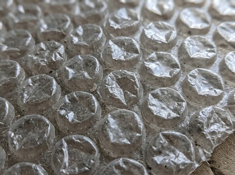 A textured bubble plastic wrap surface with a gritty, tactile feel, ideal for background textures, retro packaging effects, or recycled material aesthetics