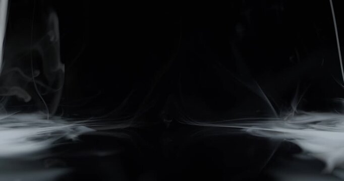 Real wispy smoke swirling on both sides with empty center stage. Vortex of wispy smoke spinning creating a mystical ghostly aura of the paranormal or a spooky Halloween background visual effect. Loop