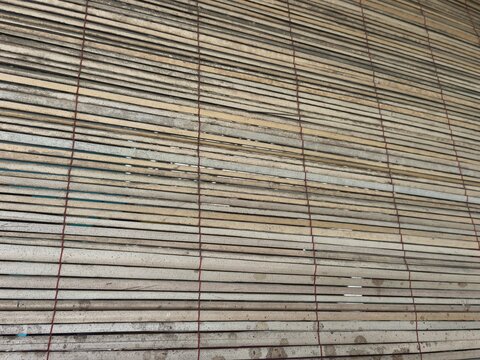 traditional bamboo blind screen texture with horizontal slats and brown string weave, ideal for rustic home interior background, natural material pattern, and wooden decor stock photo.