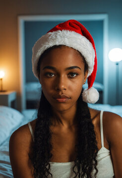 young black teenage girl wearing a red santa hat and white tank top looking with a sad lonely facial expression in a bedroom