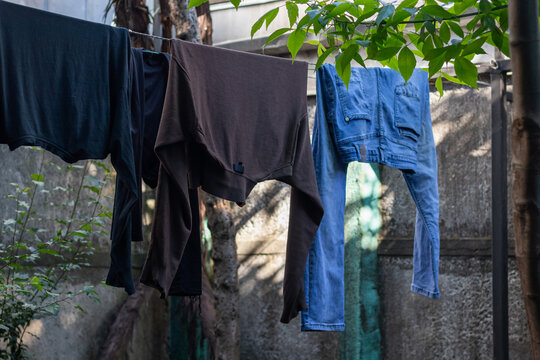 Horizontal stock photo of clothes hanging on outdoor clothesline in backyard