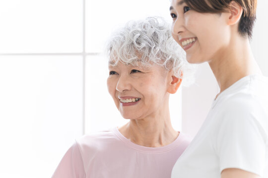 ヨガをする若い女性とシニア女性　健康イメージ