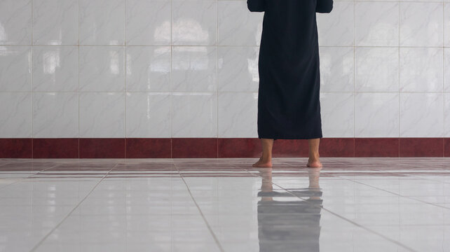 Person in Black Robe Standing in Prayer in Mosque