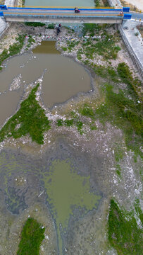 Aerial View of Polluted River Under Bridge