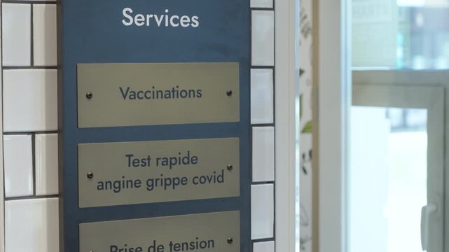 Pharmacy service sign listing vaccinations and rapid covid flu strep tests indoors
