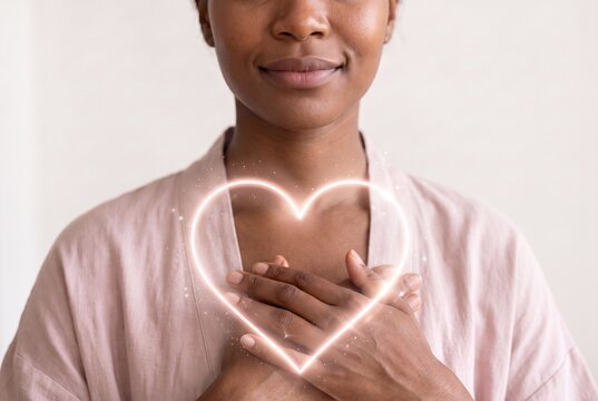 Calm Black woman with hands on heart and glowing heart symbol, mindfulness, self love, gratitude and positive energy concept