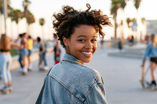 Afro girl wearing washed denim jacket, smiling with 90s grunge style fashion