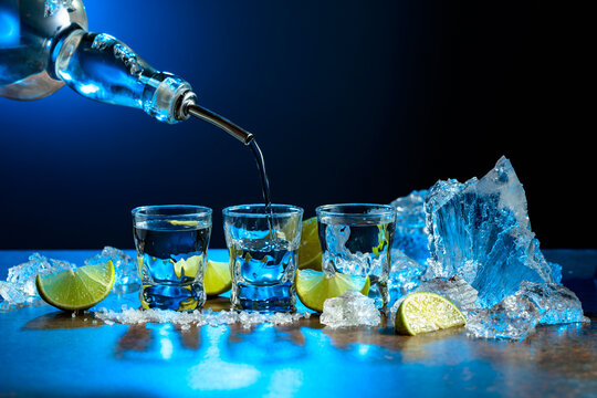 The tequila is poured from the bottle into shot glasses.
