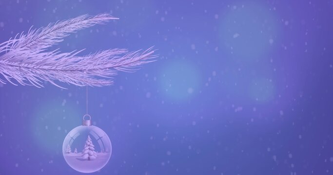 Hanging clear glass bauble showing miniature tree with snow from frosty branch at studio