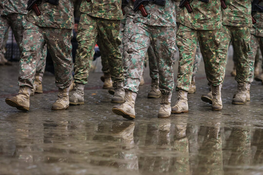 Romanian army soldiers march during a military ceremony on a rainy day