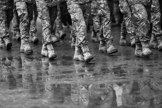 Romanian army soldiers march during a military ceremony on a rainy day