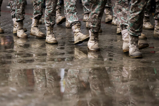 Romanian army soldiers march during a military ceremony on a rainy day