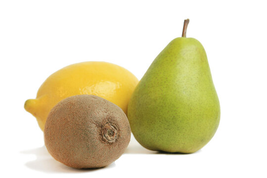 Group of whole fresh organic fruits including yellow lemon green pear and brown hairy kiwi isolated white background
