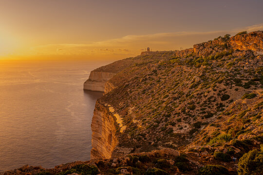Rugged Dingli Cliffs Coastline Plunging into Sea at Golden Hour with Famous Telecommunications Radar Dome on Horizon, Malta