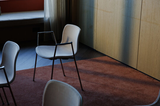 Three chairs in a conference room with subtle sunlight illuminating the space.