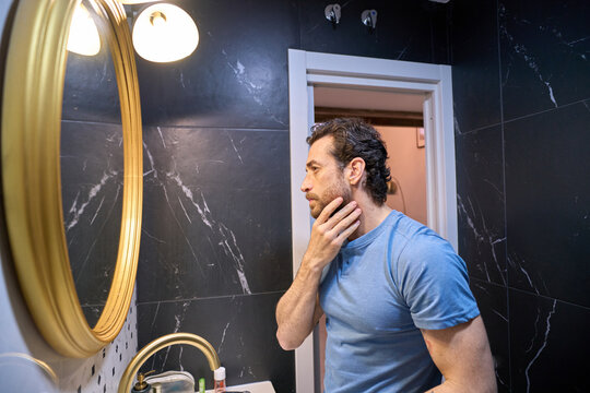 Man checking beard and skin during morning routine