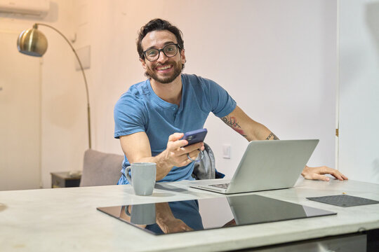 Young man remote working at home smiling