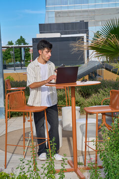 Young man entrepreneur working on laptop outdoors