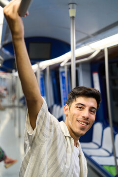 Young man commuting with public transport smiling