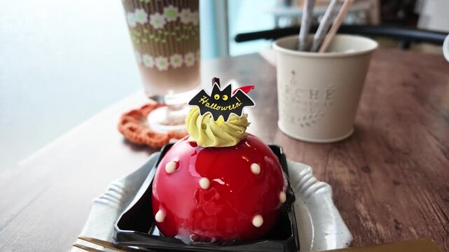 ハロウィンのケーキ 赤いグラサージュとコウモリの飾り カフェのテーブル 4K実写