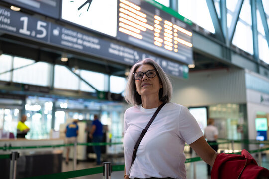 White woman waiting at airport security checkpoint under departure