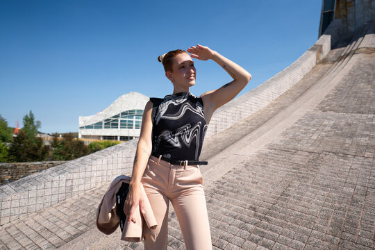 Businesswoman posing outdoors near modern urban architecture