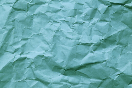 Light blue crumpled paper texture with deep folds and uneven rough surface pattern