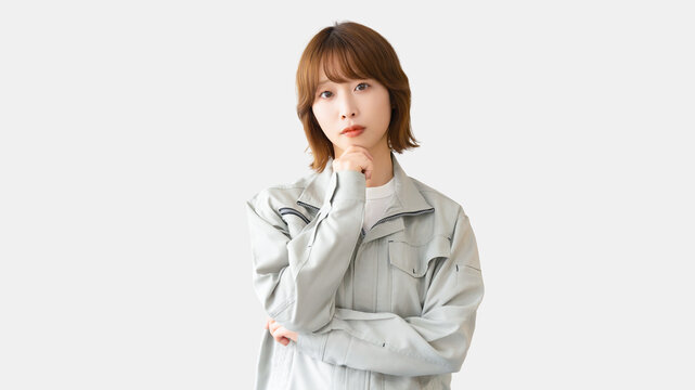 考えごとをする作業服を着た女性