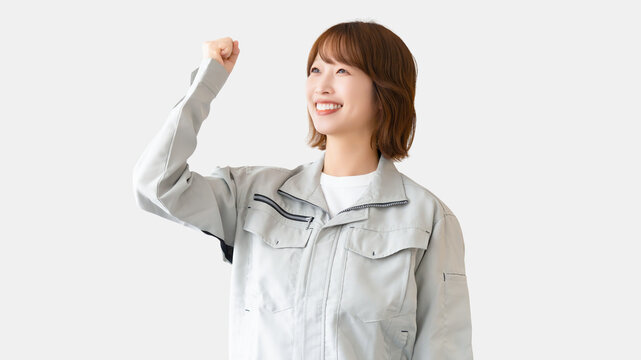 ガッツポーズをする作業服を着た女性