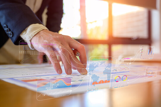 Businessman using pen analysing data charts on table in modern office in Business planning and investment financial data analytics graph Financial management technology concept.