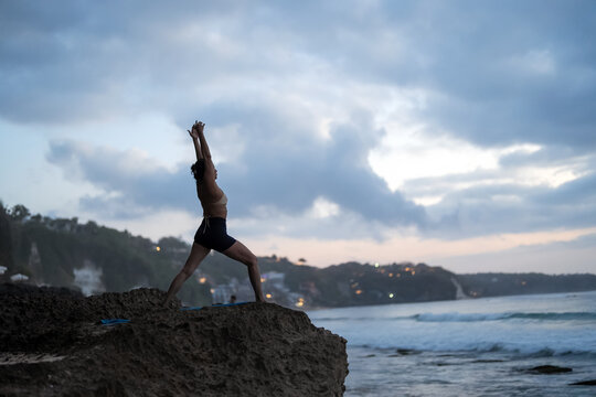Serene asian woman practicing yoga and mindfulness on a peaceful tropical beach