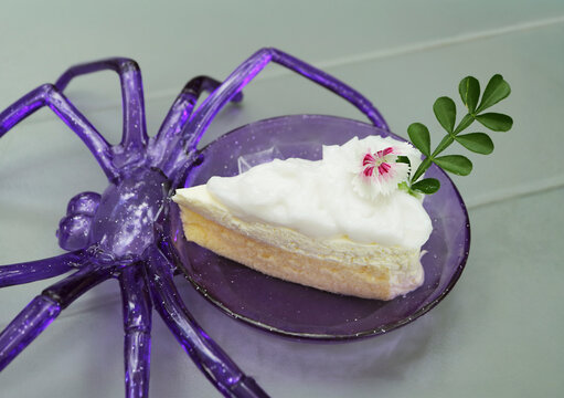 Delicious Halloween young coconut chiffon cake with white frosting served on a purple spider plate